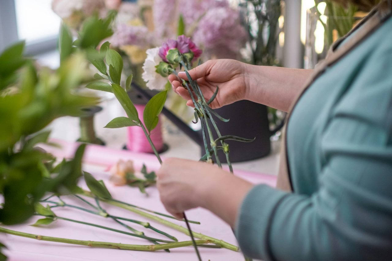 close-up-flower-shop-owner-crafts-a-breathtaking-arrangement-of-pink-and-yellow-roses-flowers.jpg